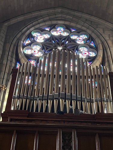 Organ in front of a circular stained glass window at St. Clement Shrine